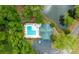 Aerial view of a community pool, pool house, and parking area nestled amidst lush greenery and a serene pond at 5514 Colonial Chatsworth Cir, North Charleston, SC 29418