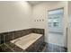 Luxurious soaking tub with tile surround and modern fixtures in a well-lit bathroom at 5514 Colonial Chatsworth Cir, North Charleston, SC 29418