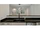 Kitchen view with sleek granite countertops, stainless steel sink, and a view of the living area at 5514 Colonial Chatsworth Cir, North Charleston, SC 29418