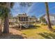 Inviting backyard featuring a screened porch, deck, stairs and lush green lawn at 60 Rice Ln, Edisto Beach, SC 29438