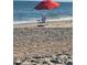 Relaxing beach scene with a Tommy Bahama chair under a red umbrella by the ocean at 60 Rice Ln, Edisto Beach, SC 29438