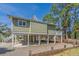 Stilt home with a ground level carport, outdoor stairs and a lush green lawn at 60 Rice Ln, Edisto Beach, SC 29438