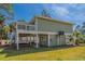 Charming two-story home featuring a porch, deck, stairs and well-maintained lawn at 60 Rice Ln, Edisto Beach, SC 29438