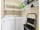 Functional laundry room with washer, dryer, and shelving for storage at 60 Rice Ln, Edisto Beach, SC 29438