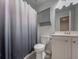 Well-lit bathroom featuring gray vanity, built-in storage, toilet and shower with curtain at 619 Hilchot Dr, Summerville, SC 29486