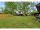 Large backyard with a wooden fence, storage shed, mature trees, and plenty of space for outdoor enjoyment at 6305 Brandt St, North Charleston, SC 29406