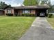 Charming brick home with well-manicured lawn, mature landscaping, and carport at 6305 Brandt St, North Charleston, SC 29406