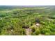 Aerial view of a home nestled among trees with a pond at 6373 Farm House Rd, Ravenel, SC 29470