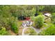Charming property featuring a white farmhouse, detached garage, and tranquil pond surrounded by lush trees at 6373 Farm House Rd, Ravenel, SC 29470