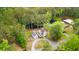 Picturesque aerial view of charming white farmhouse, detached garage, and tranquil pond surrounded by lush greenery at 6373 Farm House Rd, Ravenel, SC 29470