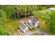 Scenic aerial view of white farmhouse with inviting front porch, detached garage, and cozy fire pit area at 6373 Farm House Rd, Ravenel, SC 29470
