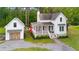 Stunning aerial view of a white home with a detached garage surrounded by lush greenery at 6373 Farm House Rd, Ravenel, SC 29470