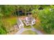 Picturesque aerial view of charming white farmhouse, detached garage, and tranquil pond surrounded by lush greenery at 6373 Farm House Rd, Ravenel, SC 29470