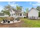 Inviting backyard featuring a fire pit area, patio space, and picturesque views of the charming house at 6373 Farm House Rd, Ravenel, SC 29470