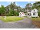 Beautiful property with a charming white home, detached garage, and a long gravel driveway at 6373 Farm House Rd, Ravenel, SC 29470