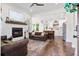 Bright open-concept living room with a fireplace and seamless kitchen view at 6373 Farm House Rd, Ravenel, SC 29470