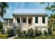 Charming white two-story home with a inviting front porch and beautiful tropical landscaping at 7059 Sounding Ln, Johns Island, SC 29455