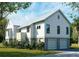 Rear exterior of home, featuring white siding, a metal roof, and a convenient two-car garage at 7059 Sounding Ln, Johns Island, SC 29455
