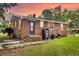 Brick ranch-style house featuring a cozy backyard, green lawn, and mature trees, capturing a peaceful outdoor setting at 757 Longfellow Rd, Charleston, SC 29407