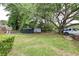 Spacious backyard with green grass, various trees, and small storage sheds at 757 Longfellow Rd, Charleston, SC 29407