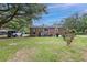 Backyard of red brick house with green grass and a white jeep parked nearby at 757 Longfellow Rd, Charleston, SC 29407