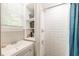 Bright bathroom featuring a tiled shower with a built in shelf, sink and shelving unit at 757 Longfellow Rd, Charleston, SC 29407