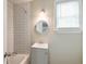 Bathroom featuring a tiled shower, sink, mirror and a window with natural light at 757 Longfellow Rd, Charleston, SC 29407