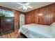 Comfortable bedroom featuring wood paneled walls, hardwood floors, a ceiling fan and a television at 757 Longfellow Rd, Charleston, SC 29407