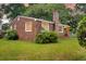 Classic brick home with a green lawn and manicured bushes during the evening twilight at 757 Longfellow Rd, Charleston, SC 29407
