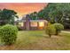 Lovely brick house with lush green lawn, windows, manicured bushes, and chimney at sunset at 757 Longfellow Rd, Charleston, SC 29407