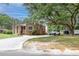 Charming brick home featuring a spacious driveway, lush green lawn, and mature trees, nestled in a quiet neighborhood at 757 Longfellow Rd, Charleston, SC 29407