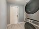 Functional laundry room with stacked Samsung washer and dryer, with wood look tiled flooring, and a white painted door at 757 Longfellow Rd, Charleston, SC 29407