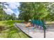 A colorful playground is situated in a green, grassy area with shady trees, offering space for outdoor activities at 7911 Windfern Ct # 1502, North Charleston, SC 29418