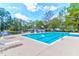 A clear blue swimming pool surrounded by lounge chairs and trees on a sunny day at 7911 Windfern Ct # 1502, North Charleston, SC 29418