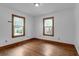 Sunlit bedroom with hardwood floors, two windows, and white walls at 809 N Magnolia St, Summerville, SC 29483