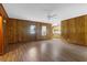 Open living room featuring wood paneling, wood flooring, and view into kitchen at 809 N Magnolia St, Summerville, SC 29483