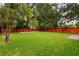 Spacious backyard featuring green grass, privacy fence, and mature trees at 83 Avondale Ave, Charleston, SC 29407