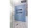 Modern shower features blue herringbone tile, two built-in shelves, and glass door with marble floor at 83 Avondale Ave, Charleston, SC 29407