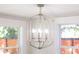 Modern chandelier with multiple bulbs hangs in front of two double-hung windows at 83 Avondale Ave, Charleston, SC 29407
