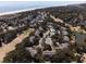 Picturesque aerial view of golf course homes with pool and tennis courts near the ocean at 9 Fairway Dunes Ln, Isle of Palms, SC 29451