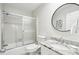 Well-lit bathroom featuring a shower with glass doors and a granite countertop vanity with a round mirror at 9 Fairway Dunes Ln, Isle of Palms, SC 29451