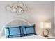 Stylishly decorated bedroom with white headboard, blue pillows, and elegant gold accents at 9 Fairway Dunes Ln, Isle of Palms, SC 29451