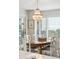 Dining room chandelier hangs over a glass dining table with six chairs near sunny windows at 9 Fairway Dunes Ln, Isle of Palms, SC 29451