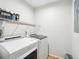 Well-lit laundry room with a side-by-side washer and dryer and wire shelving at 9 Fairway Dunes Ln, Isle of Palms, SC 29451