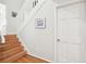 A wood staircase with white railings ascends to the upper level, naturally lit at 9 Fairway Dunes Ln, Isle of Palms, SC 29451