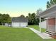 Large backyard featuring a detached two-car garage, lush lawn, and access from the porch at 104 Bryant St, Saint George, SC 29477