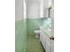 Quaint green-tiled bathroom with updated vanity, cabinet, toilet and a bright, refreshing atmosphere at 104 Bryant St, Saint George, SC 29477
