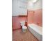 Vintage-style bathroom with pink tile, updated commode, and a built-in storage cabinet at 104 Bryant St, Saint George, SC 29477