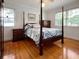 Bedroom with a four-poster bed and hardwood floors filled with natural light from two windows at 104 Bryant St, Saint George, SC 29477