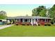 Charming brick home featuring mature landscaping, covered carport, and classic architectural details at 104 Bryant St, Saint George, SC 29477